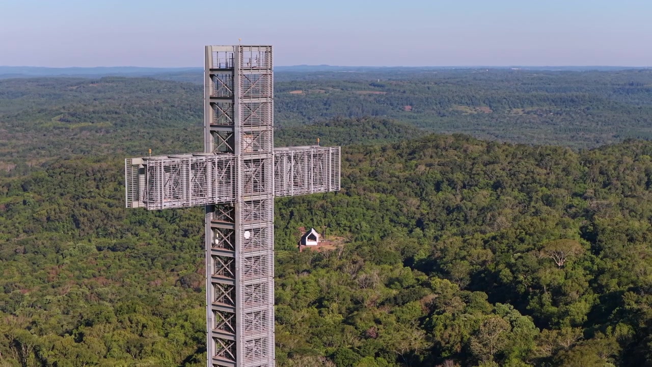 Primo piano con drone di un gigantesco monumento a croce e una piccola cappella circondati dalla foresta pluviale nel Parque Temático de la Cruz