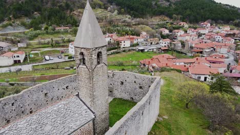historic stone church in črni kal from air as drone circles spring hillside