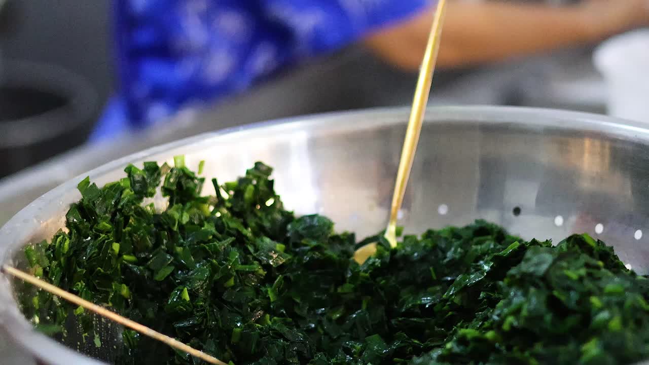 lavando las manos y exprimiendo hojas frescas de espinaca