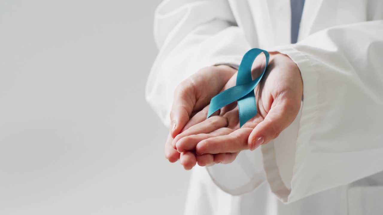 Video del busto di un medico caucasico che tiene un nastro blu per il cancro ovarico, con spazio per il testo.