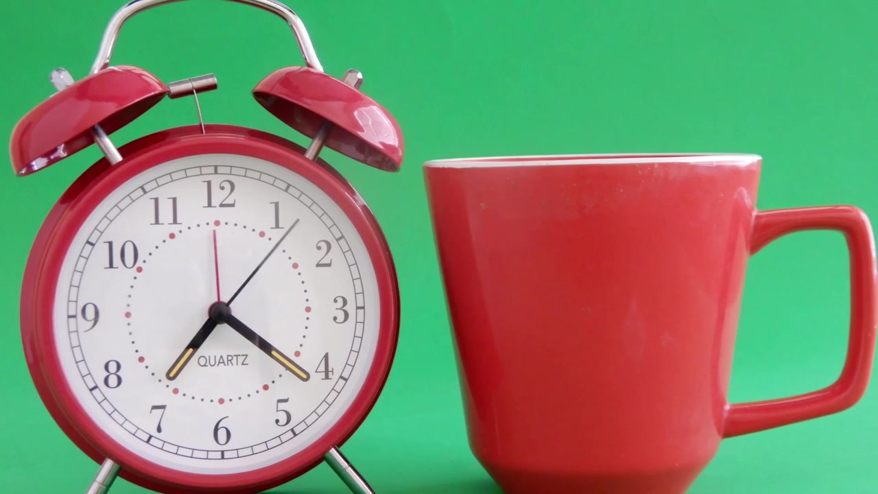 Cup of coffee to start the day along with a quick moving alarm clock .