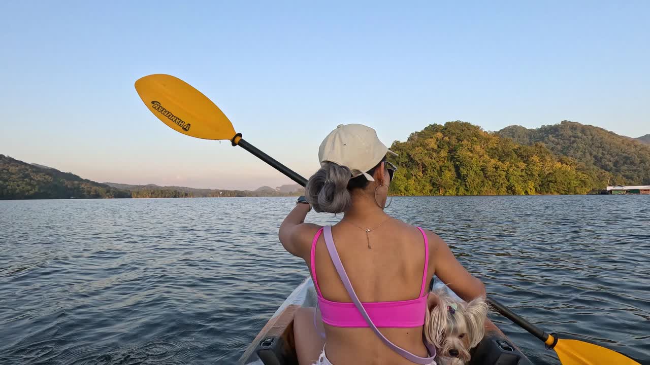 mujer y perro en kayak en un lago sereno