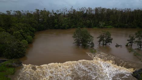 Coomera,-Gold-Coast,-2-January-2024---Reverse-aerial-view-of-Coomera-River-Causeway-under-flood-waters-from-the-2024-Storms-in-January