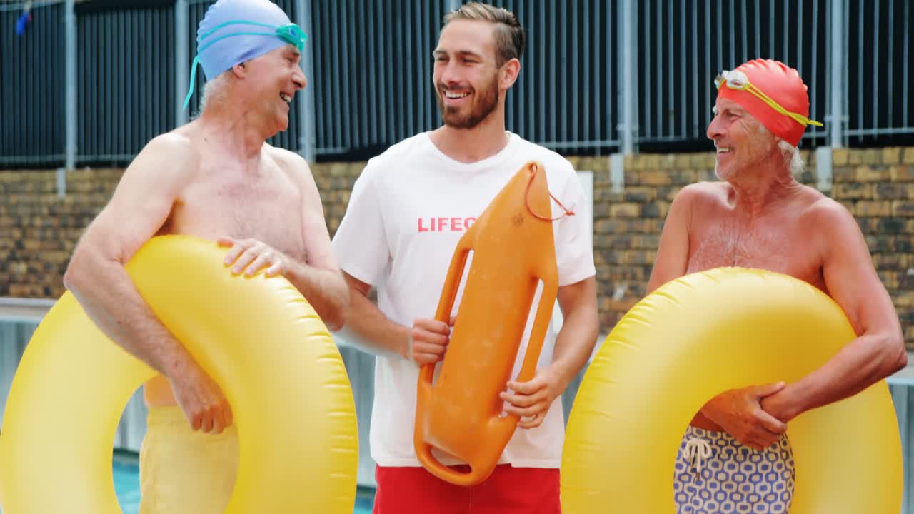 수영 코치 가 노인 들 과 상호 작용 하고 있다