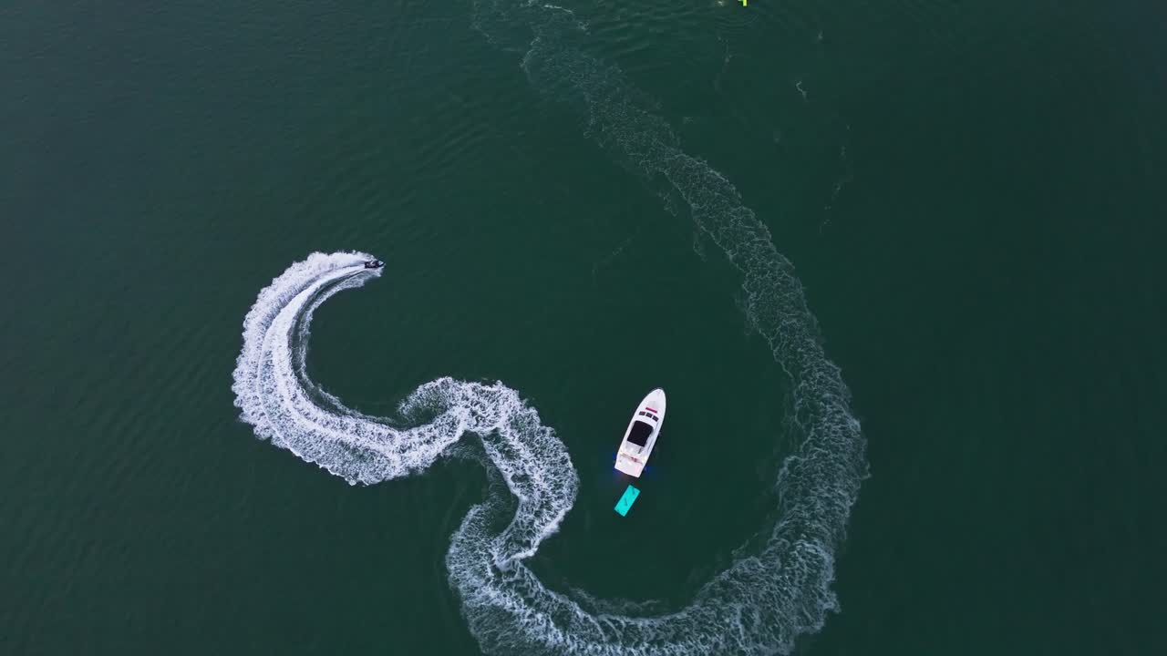 Drone shot of a jet ski doing circles in blue water of Biscayne Bay, Miami