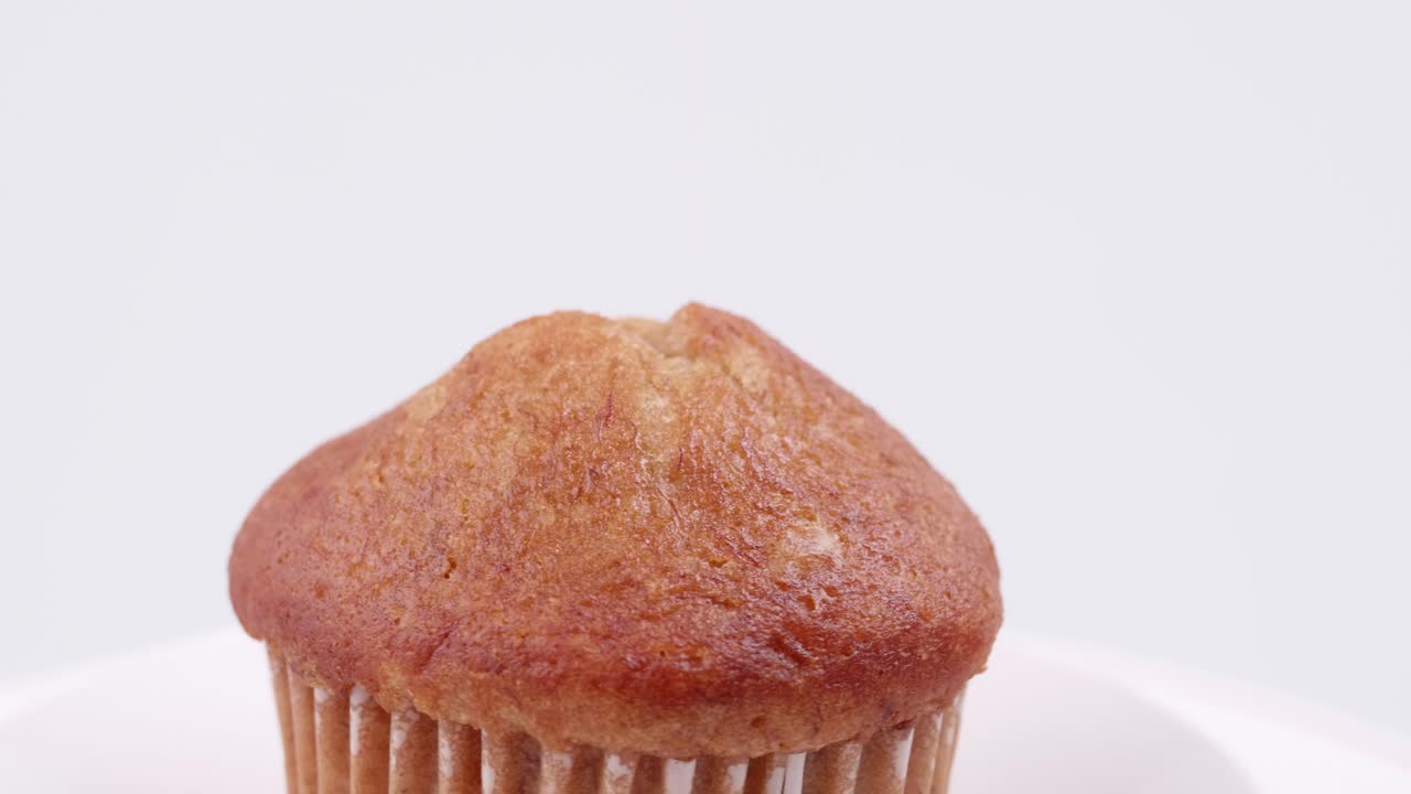 흰색 배경에 얕은 포커스가 있고 천천히 회전하는 머핀 바나나