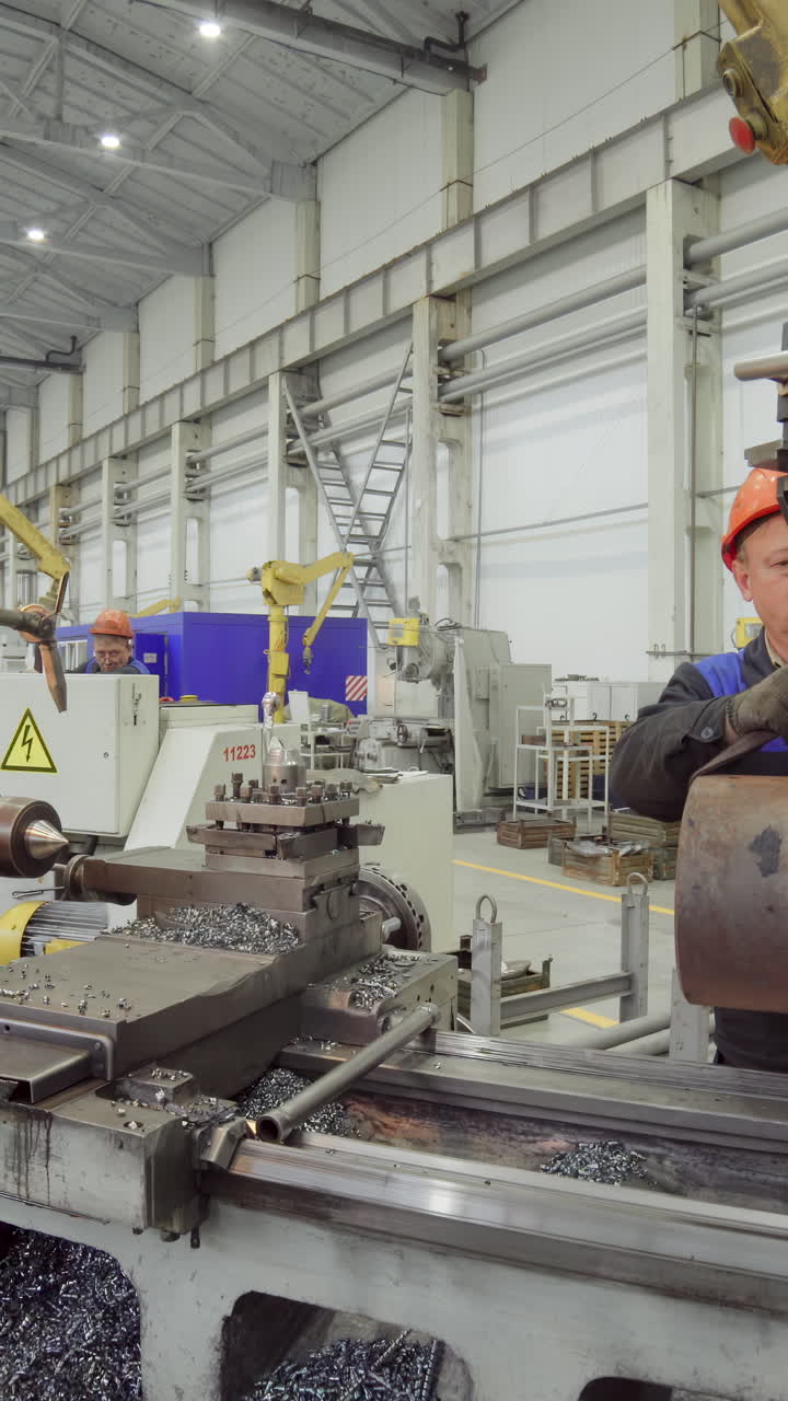 Industrial factory with workers operating metalworking machinery