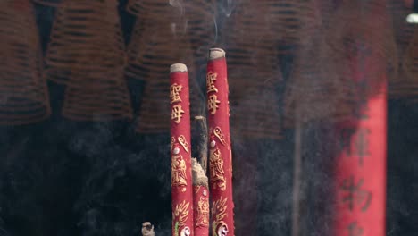 closeup of burning incense sticks fills the air at an ancient jade emperor pagoda buddhist temple in ho chi minh city, vietnam