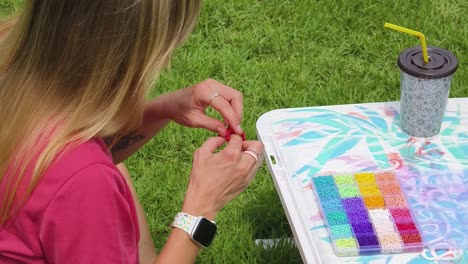 woman beading in outdoor setting