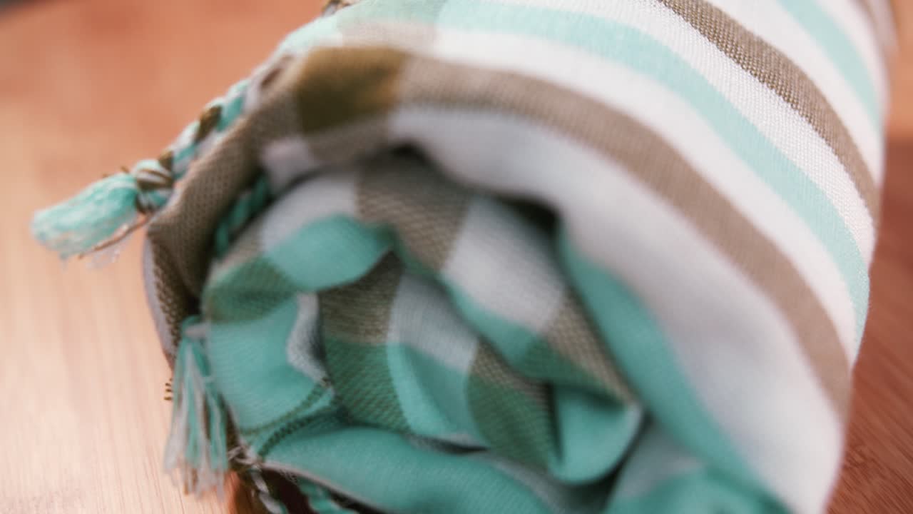 Close Shot of a Rolled Up Kroma on a Wooden Surface Spinning Into Shot