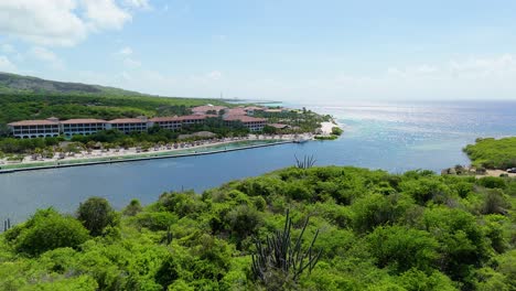 aerial push in over dry arid caribbean landscape to reveal sandals beach resort and santa barbara beach