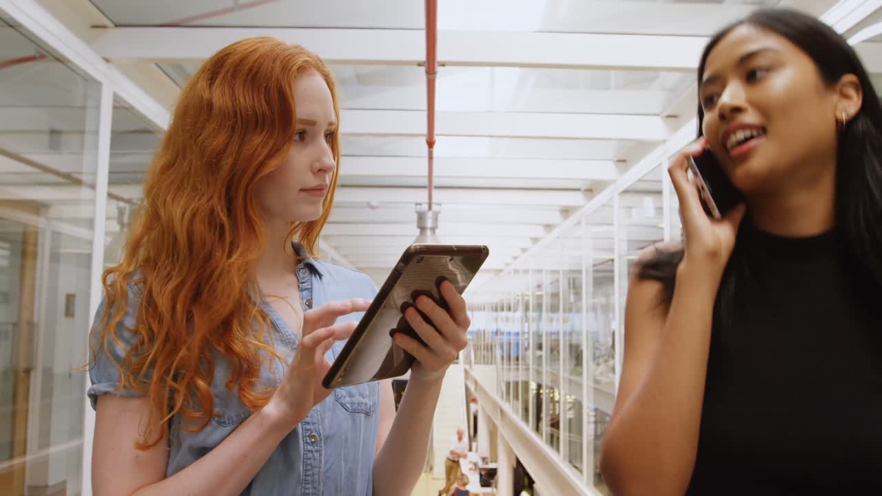 mujeres ejecutivas que usan tabletas digitales y hablan por teléfono móvil 4k