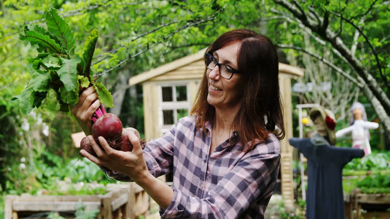 mujer madura sosteniendo verdura de remolacha 4k