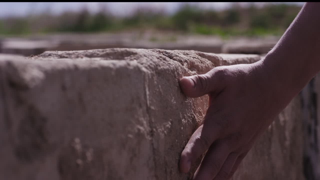 mano en la pared de ladrillo de piedra