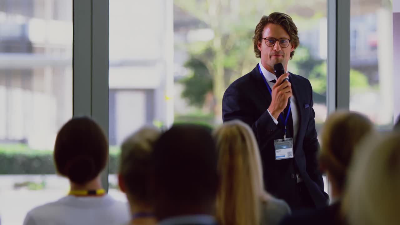 un oratore di sesso maschile parla in un seminario aziendale al modern office 4k