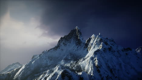 majestic snow covered mountain peak under a dramatic cloudy sky at dusk