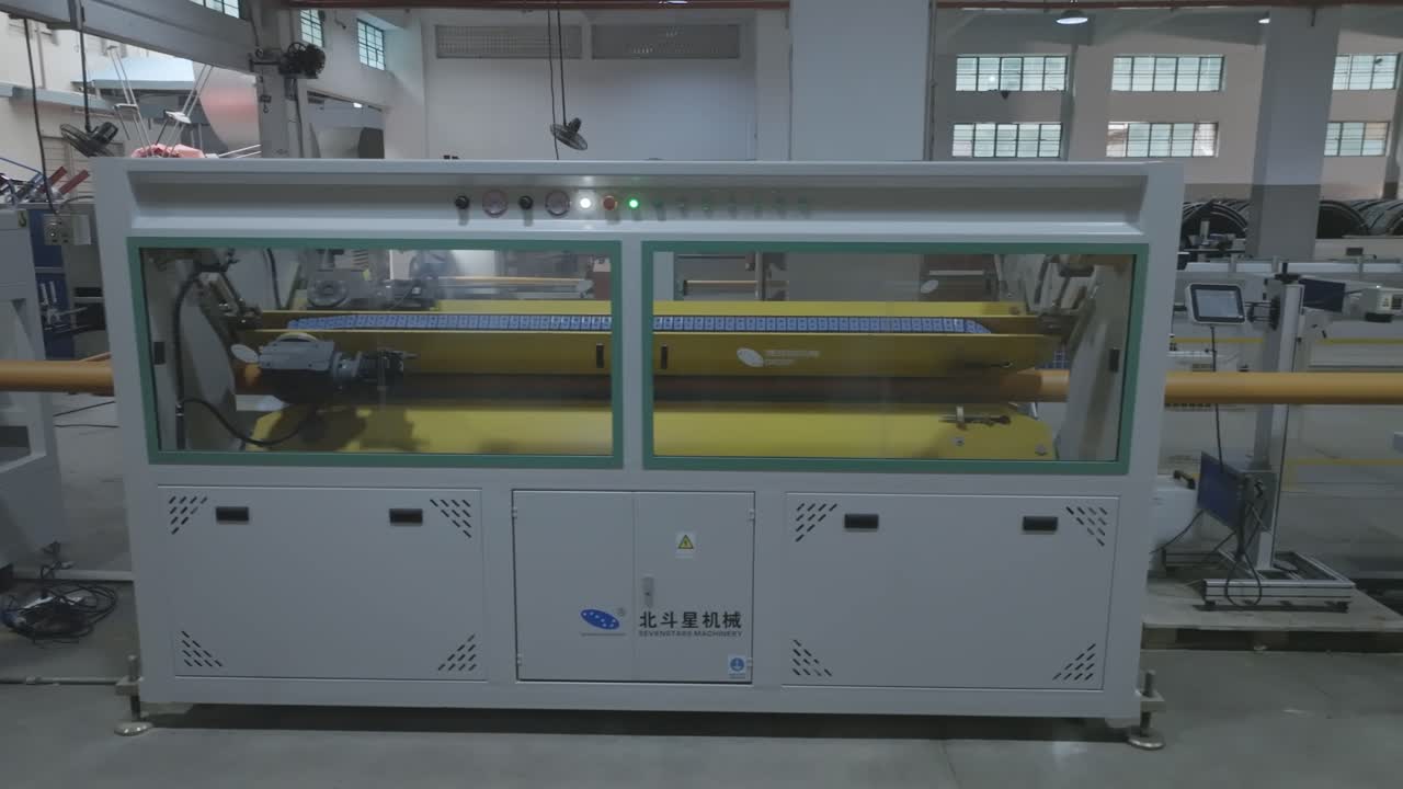 A factory worker in Karachi, Pakistan oversees the operation of a PVC pipe making machine, ensuring smooth industrial production.