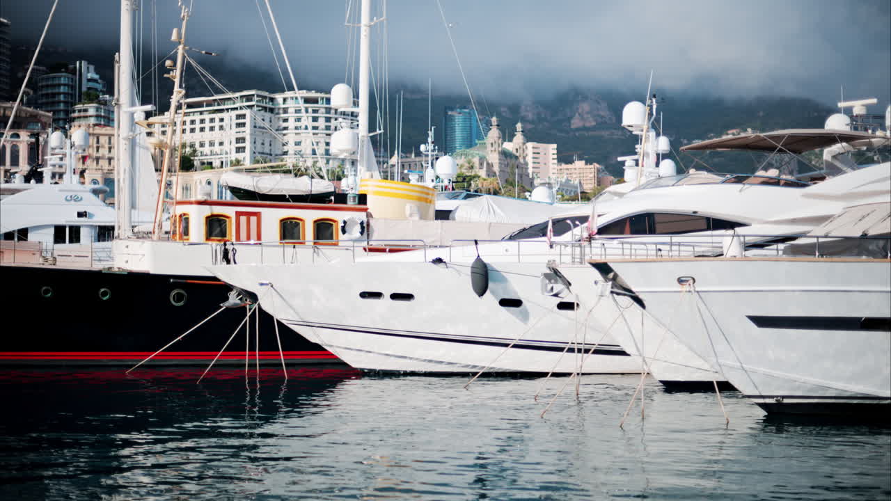 View of boats docked in the Monaco Marina with the skyline of the city on the background