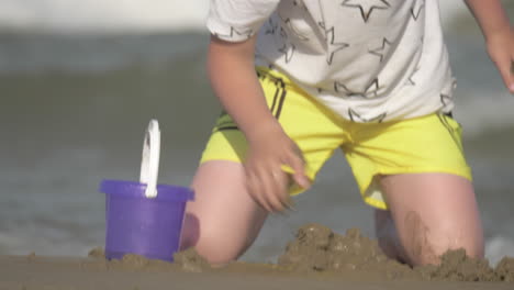 child playing with sand at the seaside