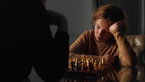 young boy intently studies the chessboard and makes a move