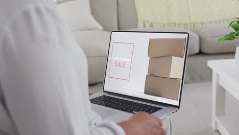 una mujer biracial usando una computadora portátil en casa comprando en línea en el día de venta del lunes cibernético, en cámara lenta