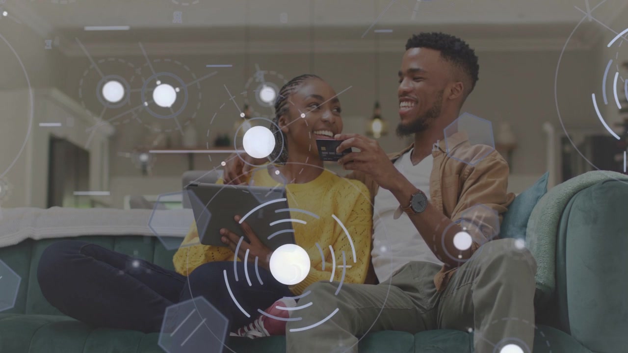 Vertical video: Woman tapping tablet while man moving phone closer on sofa, IoT overlay sharing