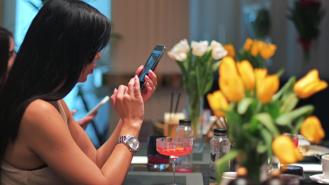 Woman in restaurant browsing social media on mobile phone