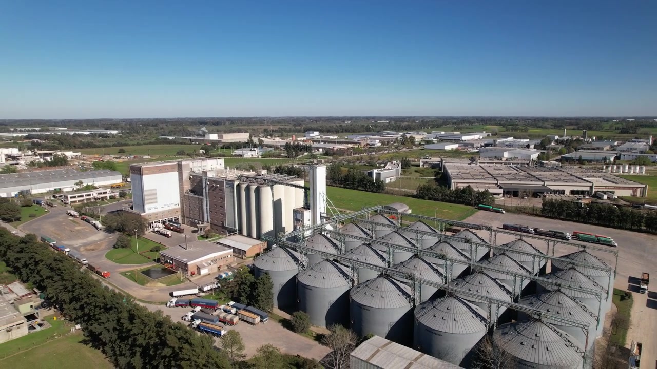 Aerial backward shot of steel grain silos at industrial plant