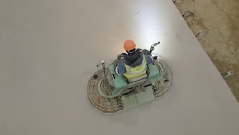 concrete floor being polished by a construction worker