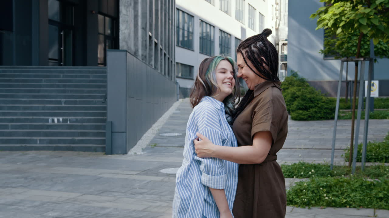 Madre e figlia che si abbracciano all'aperto.