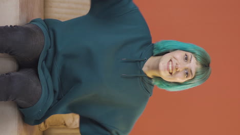 video vertical de una mujer joven experimentando alegría mirando a la cámara.