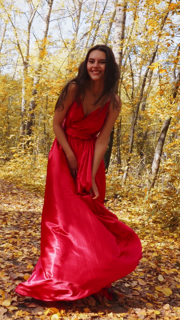 A Woman in a Flowing Red Dress Amidst Autumn Foliage, Capturing the Beauty of Nature and Fashion in a Vibrant Forest Setting