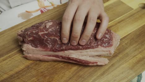 cortar la grasa extra del bistec de carne en la tabla de cortar