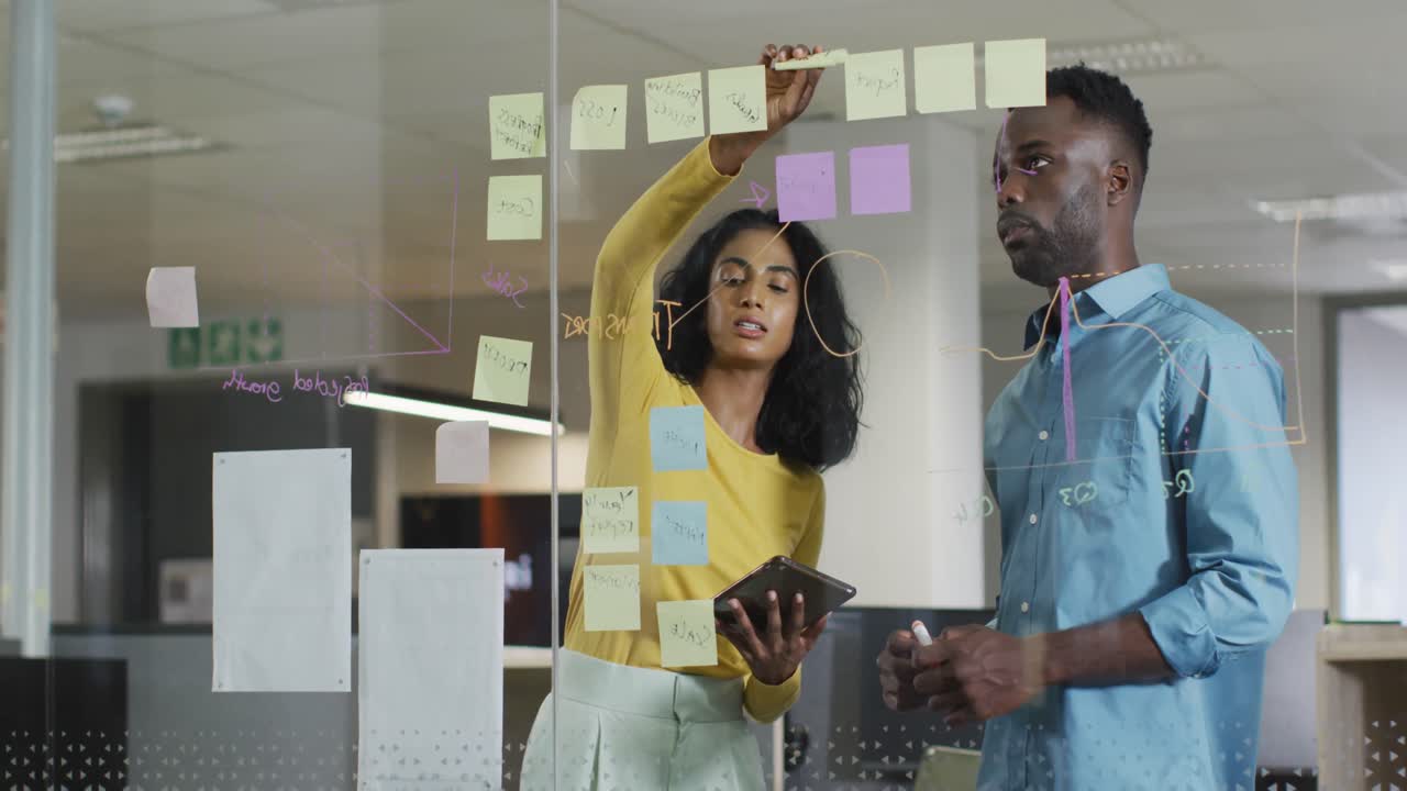Video of happy diverse businesswoman and businessman brainstorming in office