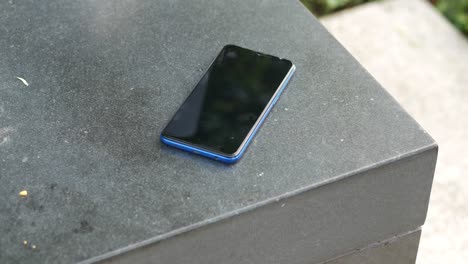 blue smartphone on a dark gray surface