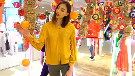 asian woman with a beautiful smile in a department store looking at home decorations in a chinese style