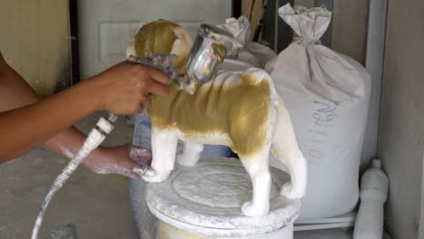 woman hand in glove paint pug dog statue details by airbrush