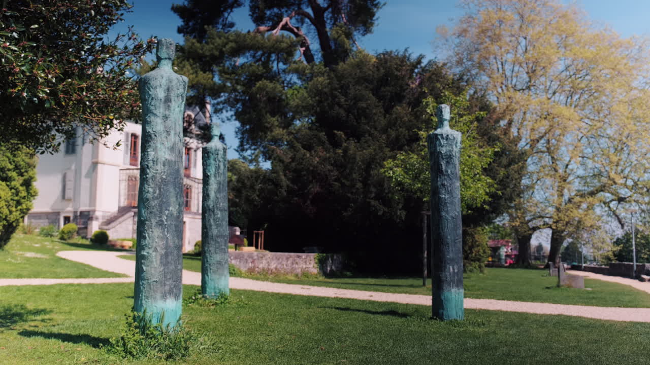 Static shot of three statues next to Conservatory Of Music L'Ouest Vaudois during the day in Nyon, canton of Vaud, Switzerland