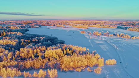 Isolated-car-crossing-frozen-landscape-at-sunset-and-forest-during-foliage