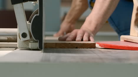 carpenter using a table saw to cut wood