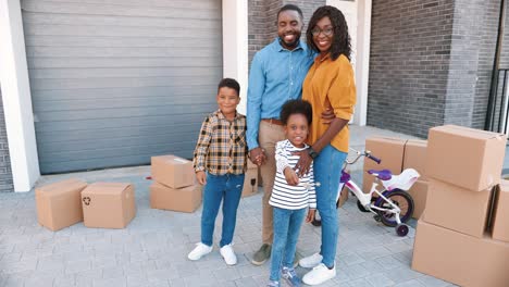 Retrato-De-Una-Familia-Afroamericana-Feliz-Con-Niños-Pequeños-En-Una-Casa-Nueva-En-Un-Suburbio-Sonriendo