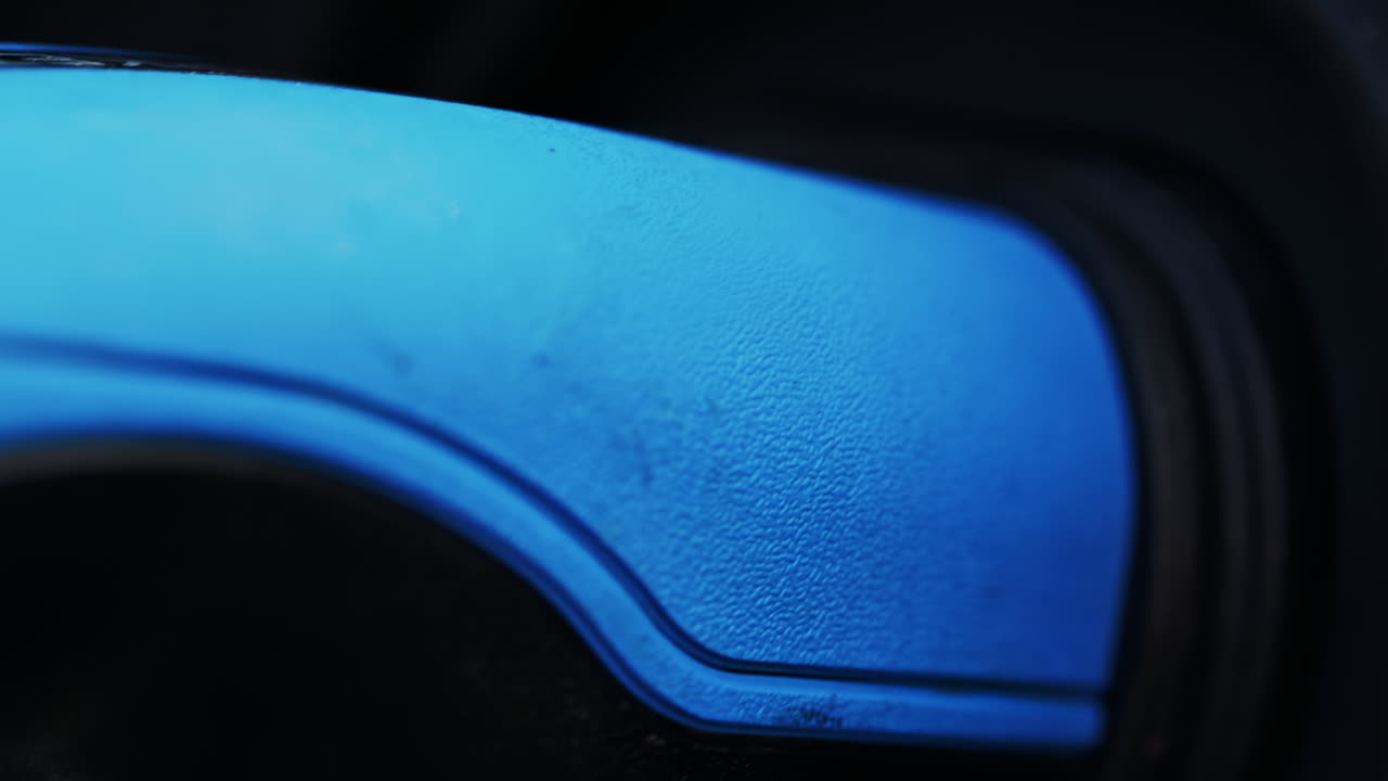 Close up of a blue electric car charger plugged into a white car