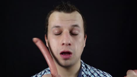 man reacts to sausages being held near his face