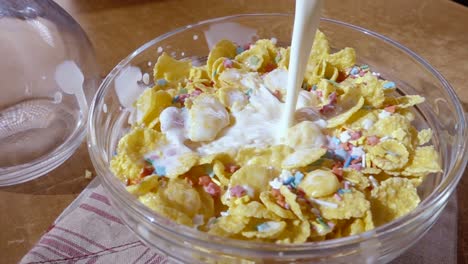 flocos de maíz amarillos crujientes en el cuenco para la mañana un delicioso desayuno con leche. cámara lenta con toma de seguimiento de rotación.