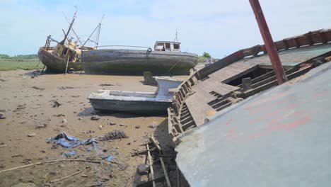 Close-pan-of-derelict-shipwreck-with-other-wrecks-in-background,-slow-motion,-Fleetwood-Docks,-Lancashire,-UK