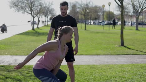 sporty muscular girl training with kettlebell in summer park.