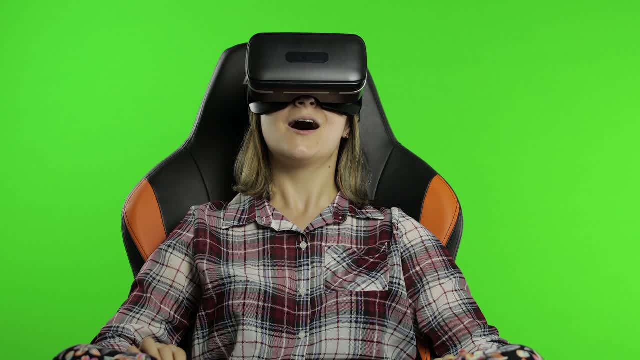 Young woman using VR headset helmet to play game. Watching virtual reality 3d 360 video. Chroma key