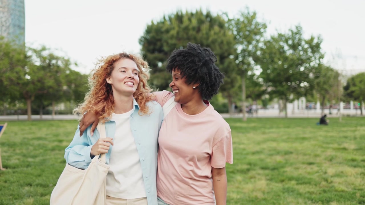 Two Happy Diverse Women Walking and Talking in a Park