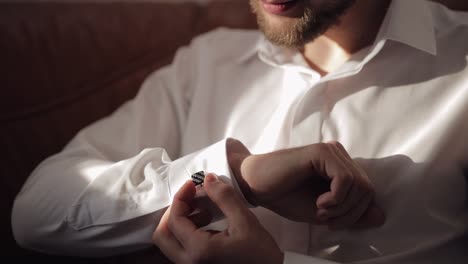 Handsome-groom-man-fixes-his-cuffs-on-a-jacket-with-cufflinks.-Businessman