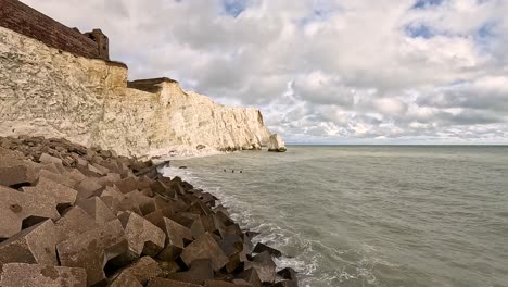 las olas golpean los acantilados en east sussex, inglaterra